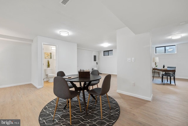 dining room featuring light wood-type flooring, baseboards, and visible vents