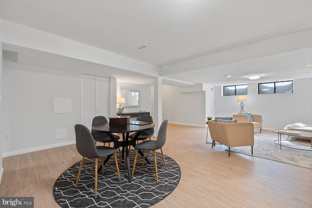 dining room featuring visible vents, light wood-style flooring, and baseboards