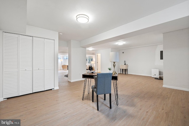 dining space featuring light wood finished floors and baseboards