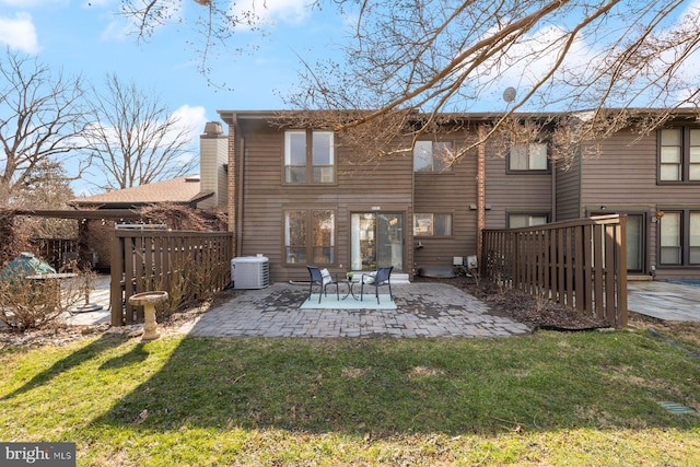 rear view of property with central air condition unit, a patio, a lawn, and fence