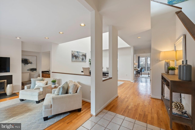 living room featuring recessed lighting, light wood-type flooring, and baseboards