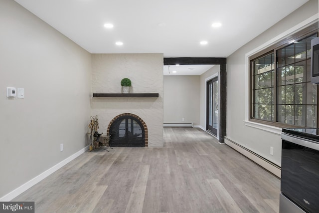 unfurnished living room featuring baseboard heating, a fireplace, and wood finished floors