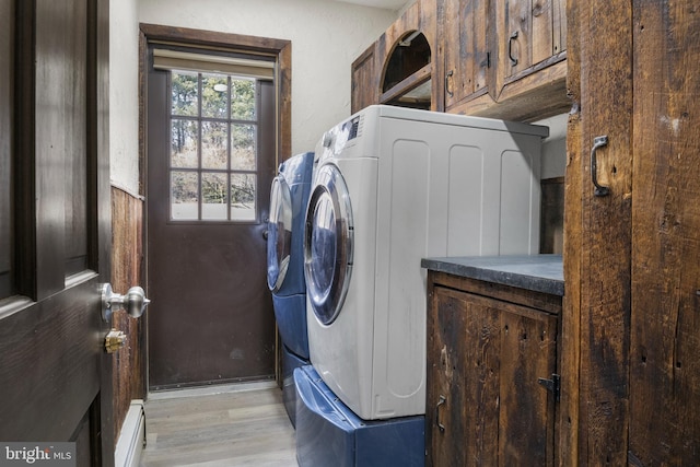 laundry room with light wood-style floors, cabinet space, independent washer and dryer, and baseboards