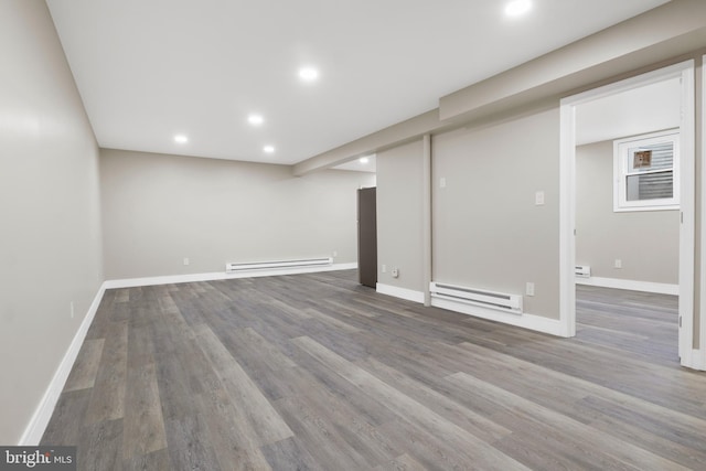 finished basement featuring baseboards, baseboard heating, wood finished floors, and recessed lighting