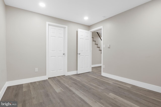 interior space with recessed lighting, wood finished floors, and baseboards