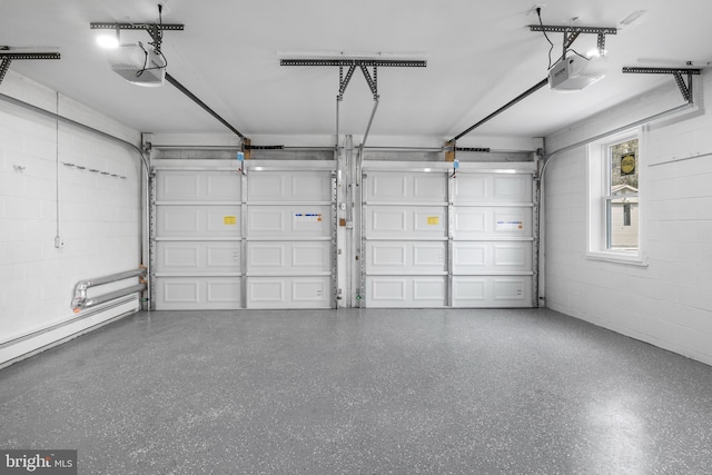 garage with a garage door opener and concrete block wall