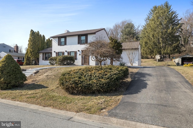 view of front of house with driveway, a garage, and a chimney