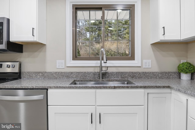 kitchen featuring stainless steel appliances, a sink, and white cabinets