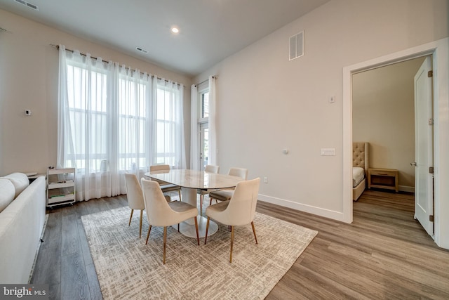 dining space with baseboards, visible vents, wood finished floors, and recessed lighting