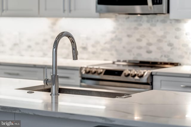 room details with gray cabinets, electric stove, and light countertops