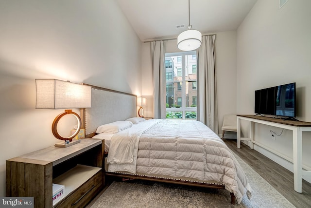 bedroom with vaulted ceiling and wood finished floors