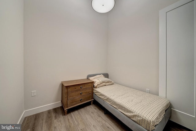 bedroom with light wood finished floors and baseboards