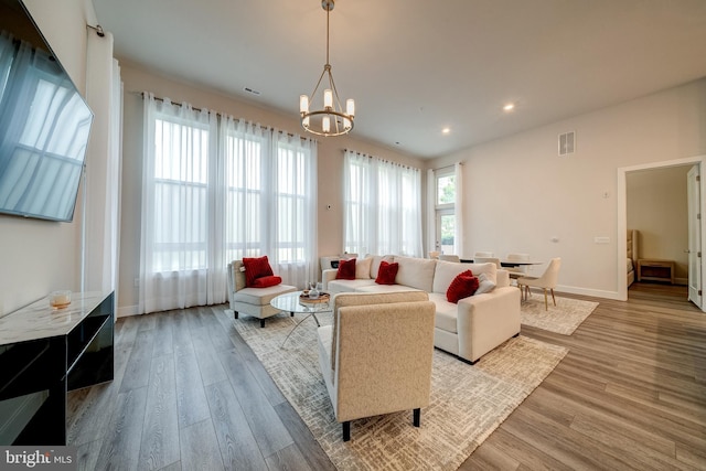 living area featuring baseboards, visible vents, wood finished floors, an inviting chandelier, and recessed lighting