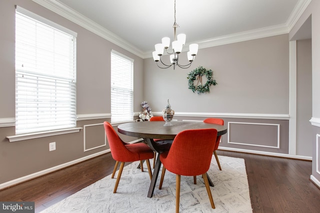 dining room featuring wainscoting, a notable chandelier, crown molding, and wood finished floors