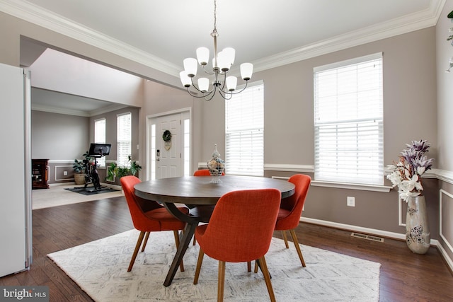 dining space featuring hardwood / wood-style flooring, plenty of natural light, visible vents, and crown molding