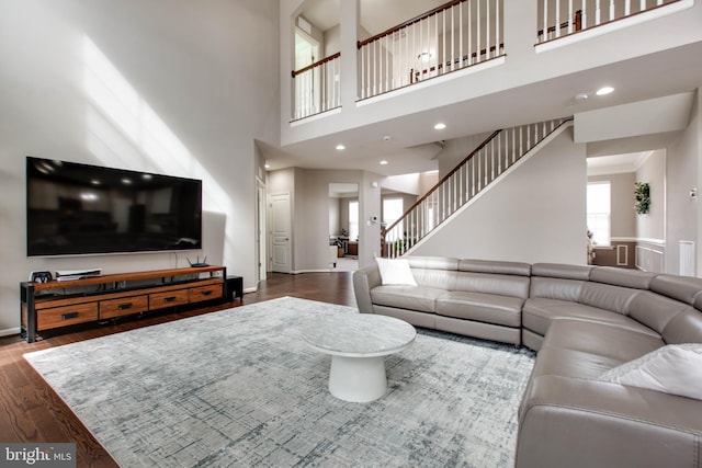 living area featuring stairs, baseboards, wood finished floors, and recessed lighting