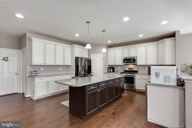 kitchen with a center island, dark wood finished floors, stainless steel appliances, recessed lighting, and white cabinetry