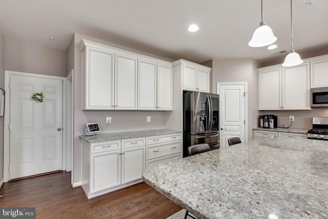 kitchen with stainless steel appliances, dark wood-type flooring, white cabinetry, and light stone countertops