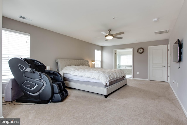 carpeted bedroom with baseboards, visible vents, a ceiling fan, and ensuite bathroom