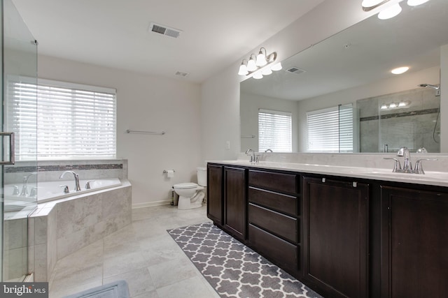 bathroom featuring visible vents, double vanity, tiled shower, and toilet