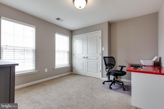 carpeted office space with visible vents and baseboards