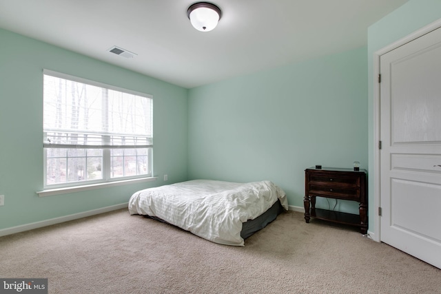 carpeted bedroom featuring visible vents and baseboards