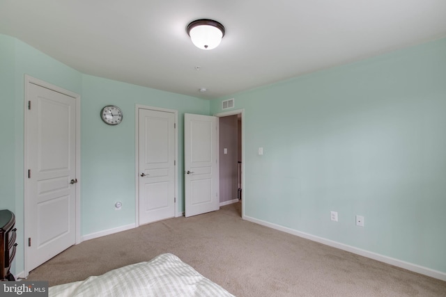 carpeted bedroom featuring visible vents and baseboards