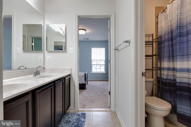 bathroom featuring toilet, a sink, visible vents, tile patterned floors, and double vanity