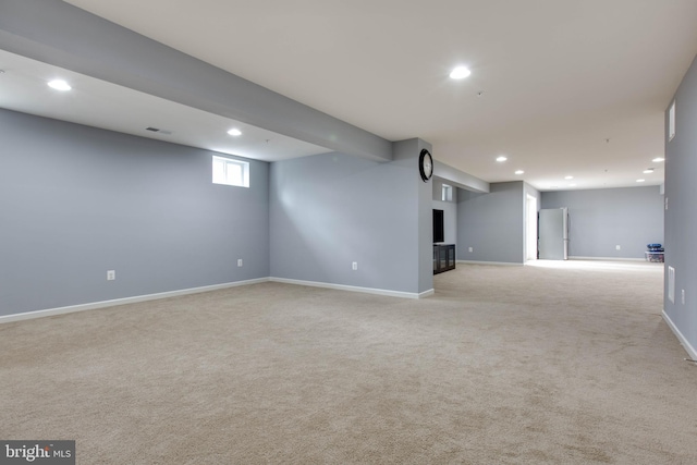 below grade area featuring recessed lighting, light colored carpet, visible vents, and baseboards