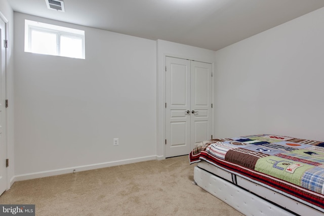 carpeted bedroom with a closet, visible vents, and baseboards