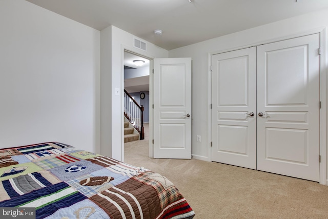 bedroom featuring visible vents, a closet, and light colored carpet