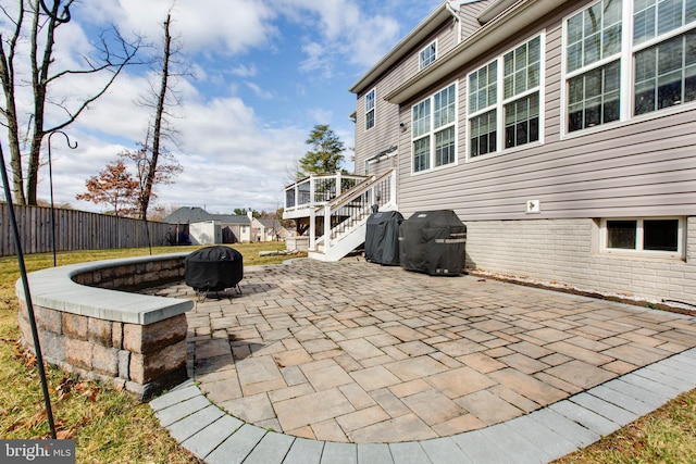 view of patio / terrace featuring a fenced backyard, stairs, a fire pit, and grilling area