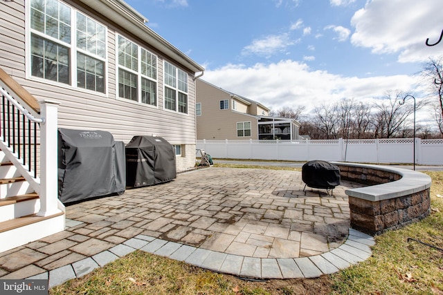 view of patio with an outdoor fire pit, a fenced backyard, and a grill