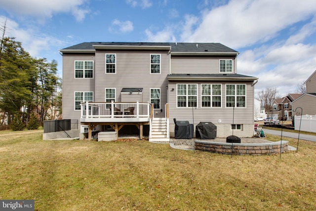 rear view of property with a wooden deck and a yard