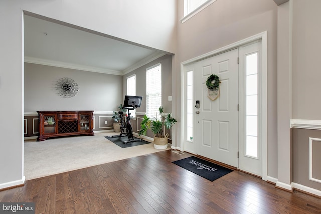 entryway with a healthy amount of sunlight, wood-type flooring, and crown molding