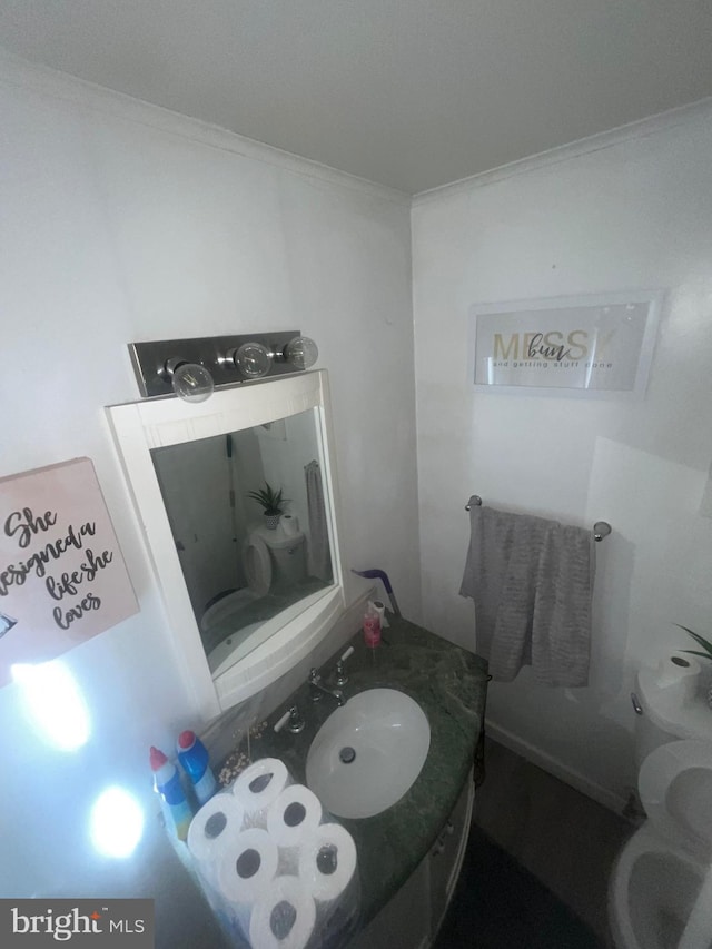 half bathroom with toilet, vanity, and crown molding