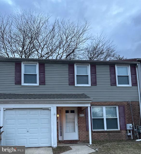 view of front of property with a garage and brick siding