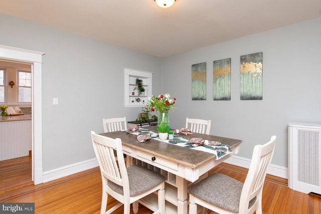 dining space featuring baseboards and light wood finished floors