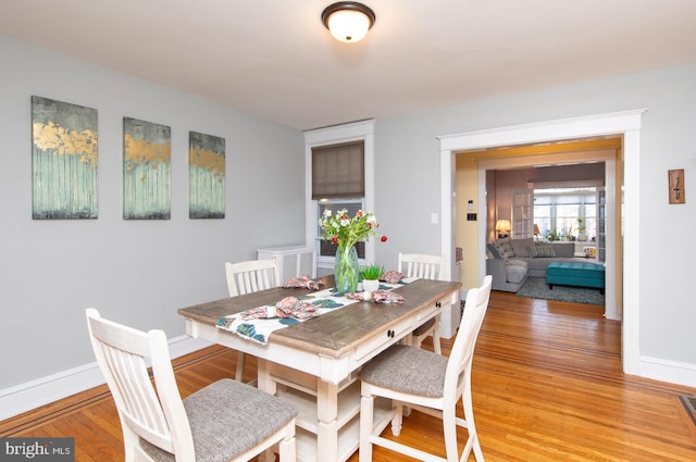 dining area with baseboards and light wood finished floors