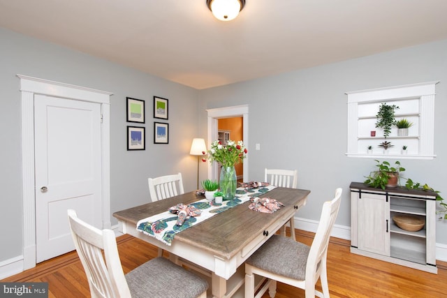 dining room with baseboards and light wood finished floors