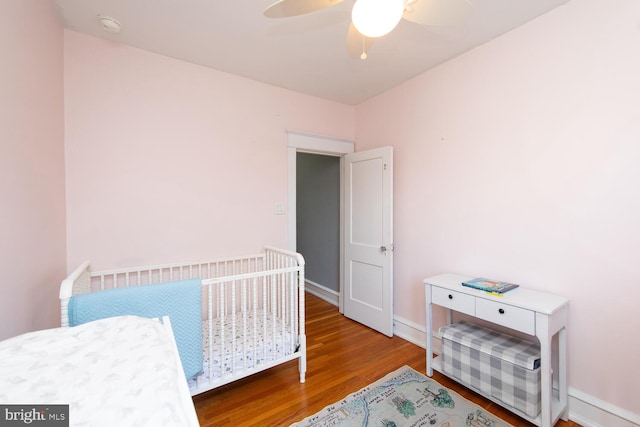 bedroom with a ceiling fan, baseboards, and wood finished floors