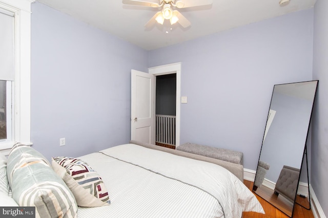 bedroom with wood finished floors, baseboards, and ceiling fan