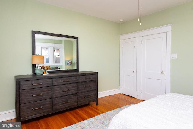 bedroom with baseboards and wood finished floors