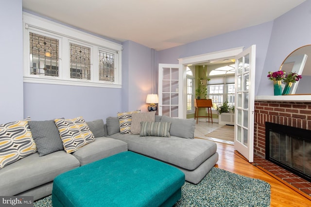 living area featuring a brick fireplace and wood finished floors