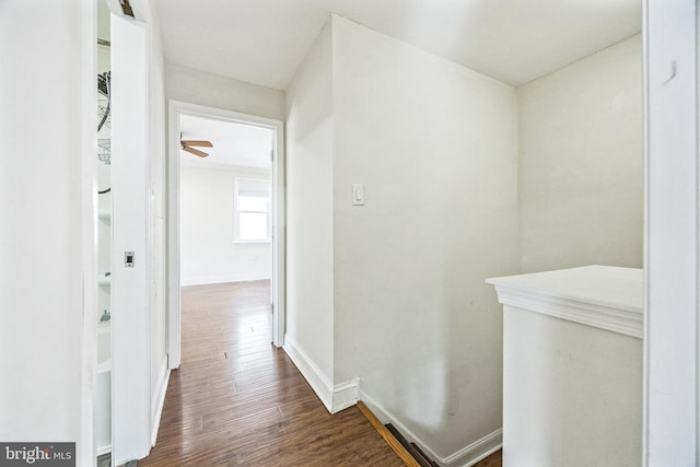 hall featuring baseboards and wood finished floors