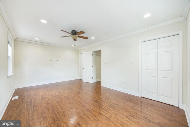 interior space featuring baseboards, ornamental molding, and wood finished floors