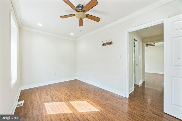 unfurnished room with ornamental molding, wood finished floors, visible vents, and baseboards