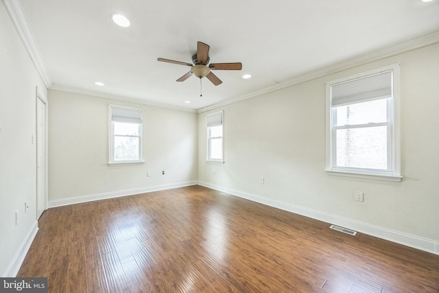 unfurnished room featuring dark wood-style floors, ornamental molding, visible vents, and baseboards