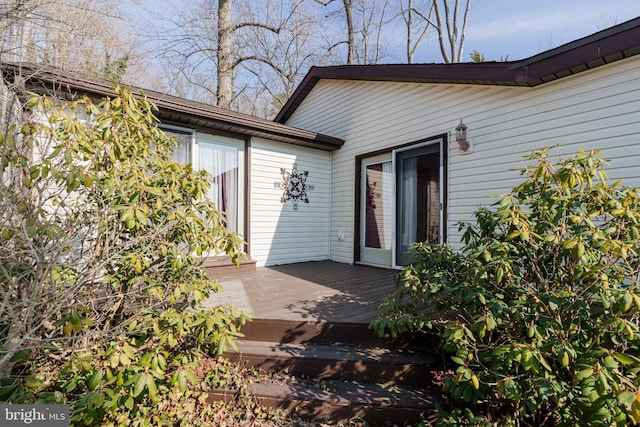 doorway to property featuring an attached garage and a wooden deck