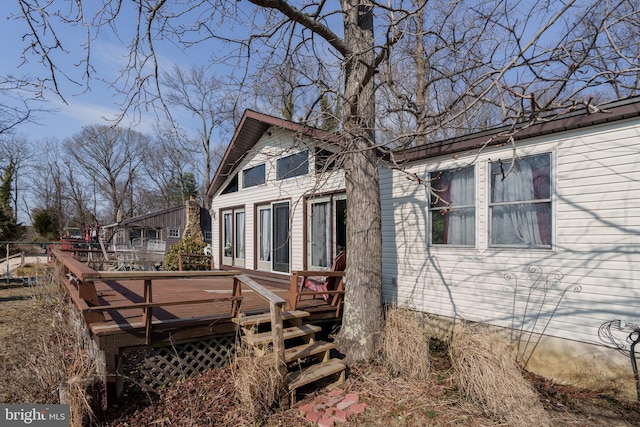 rear view of house featuring a wooden deck